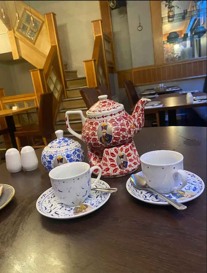 Persian tea set with decorative red teapot, matching sugar bowl, and cups.